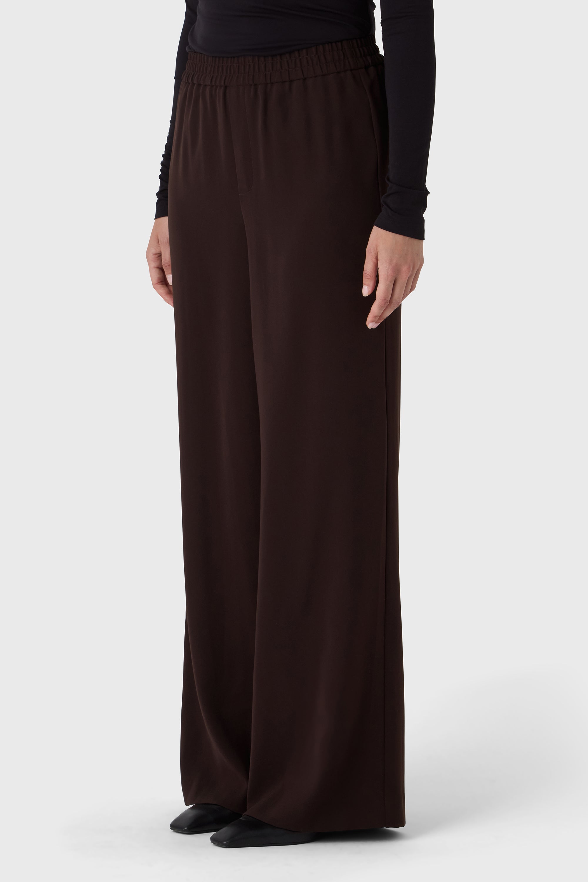 Brown wide-leg pants worn by a person on a white background