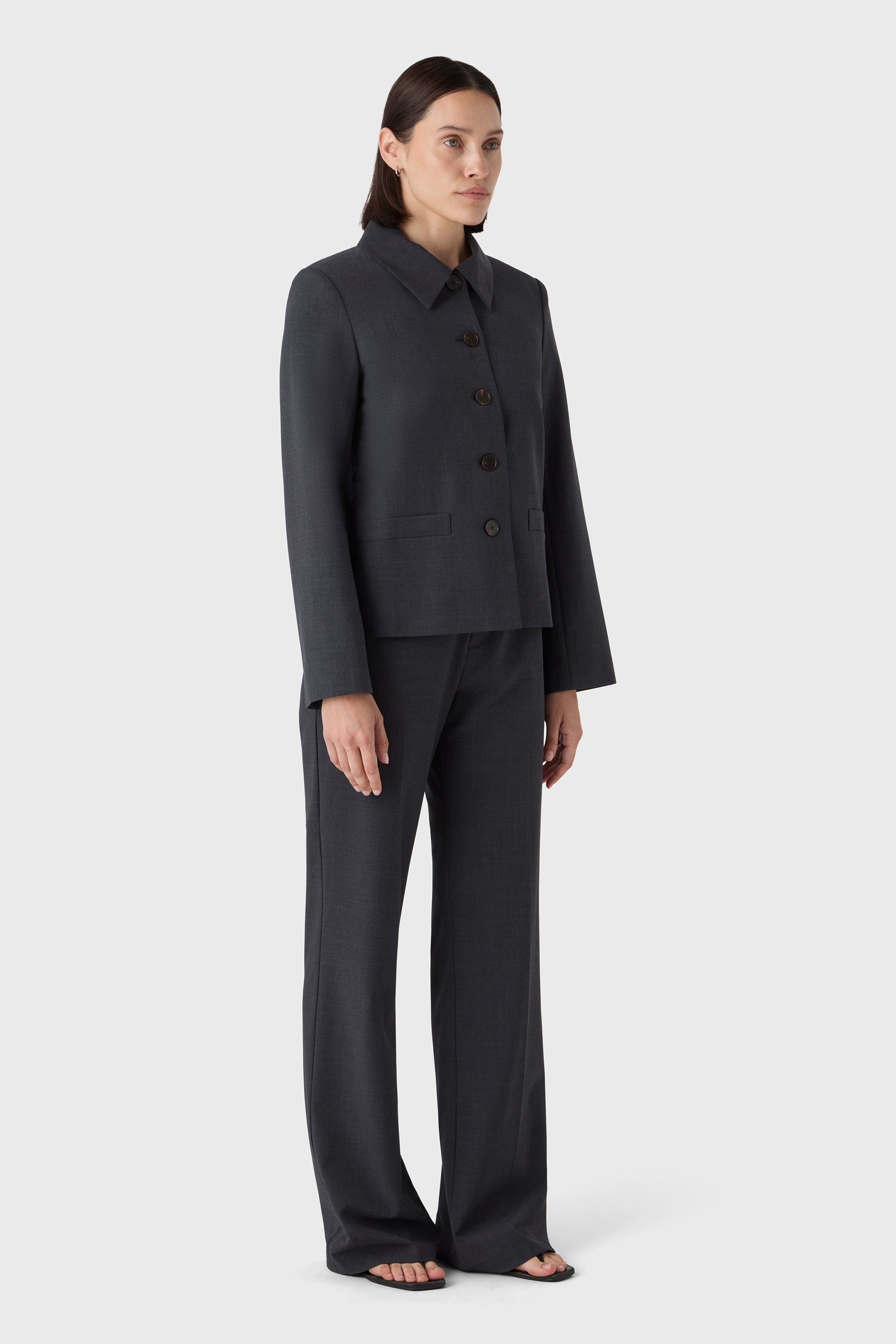 Woman wearing a dark gray suit on a white background