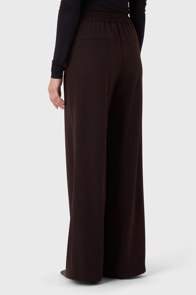 Brown wide-leg pants worn by a person on a white background